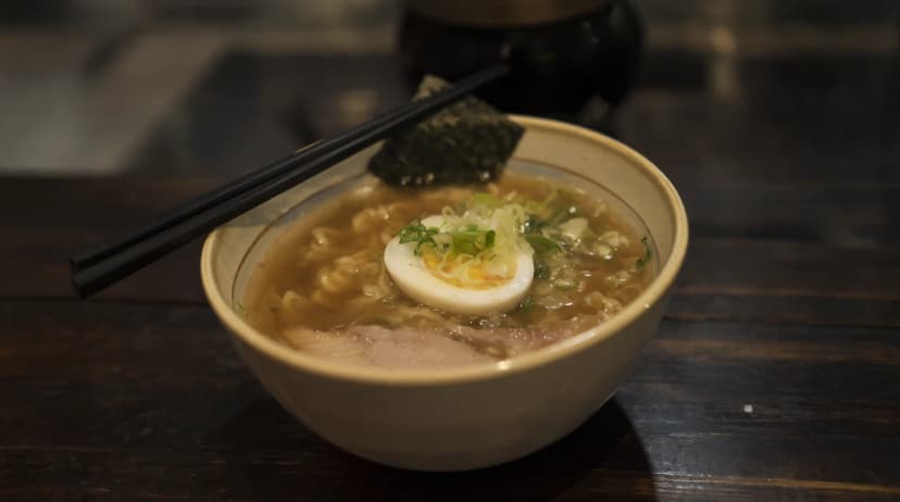 Qwen Image 2.1 image: a bowl of steaming ramen on a dark wooden counter